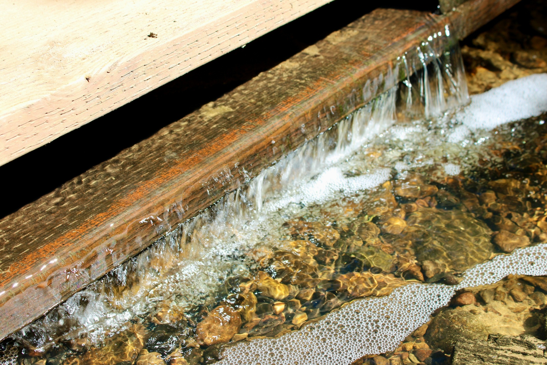 Fuite d'eau active sur une structure bois avec écoulement visible