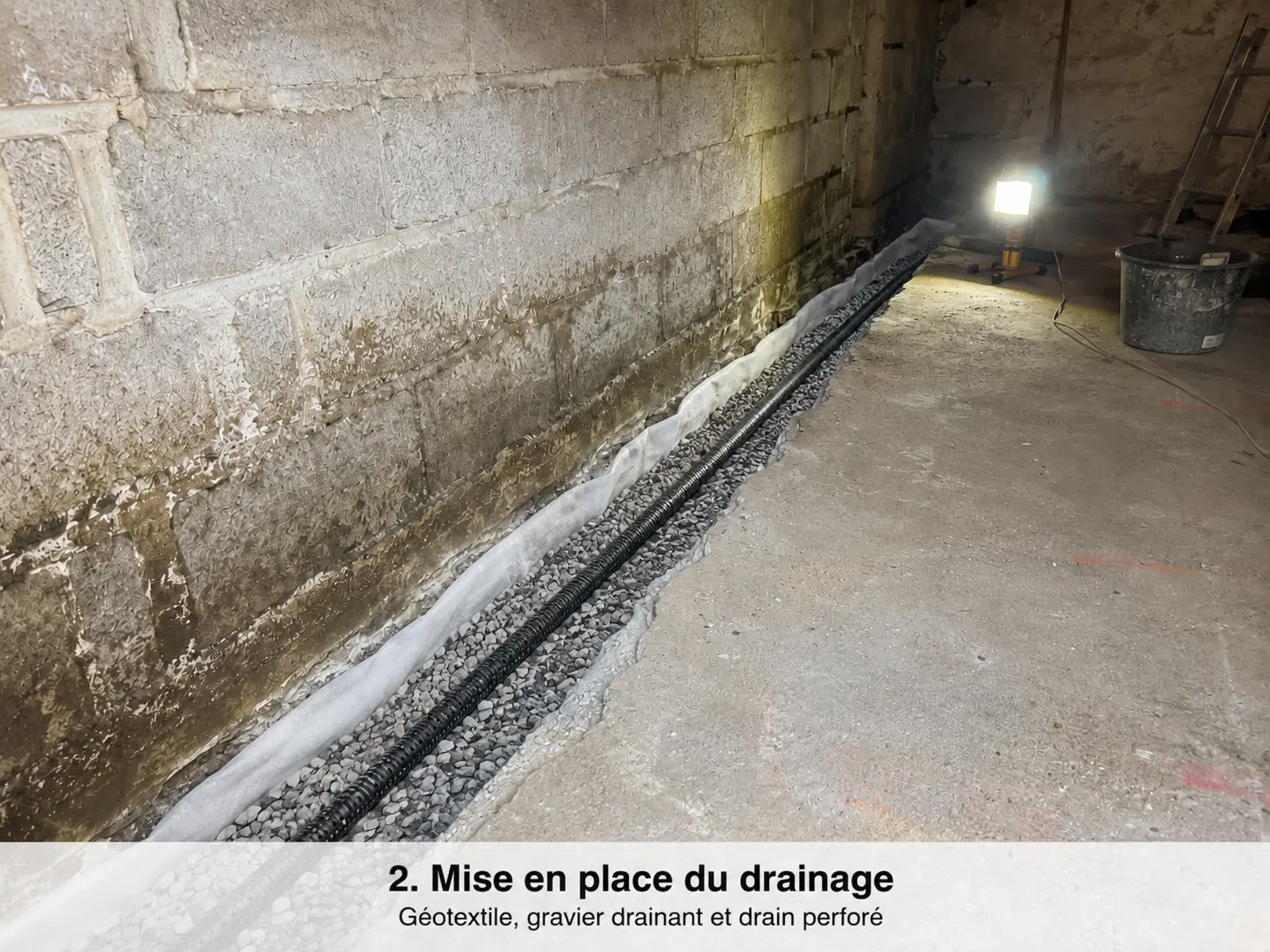 Drain perforé avec gravier et géotextile installé dans une cave